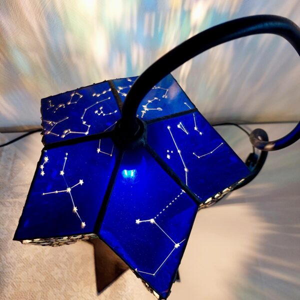 星をイメージした、5角形のステンドグラスのランプです。上部には被せガラスを使用し、星座をブラスト加工してあり、まるでプラネタリウムのようです。