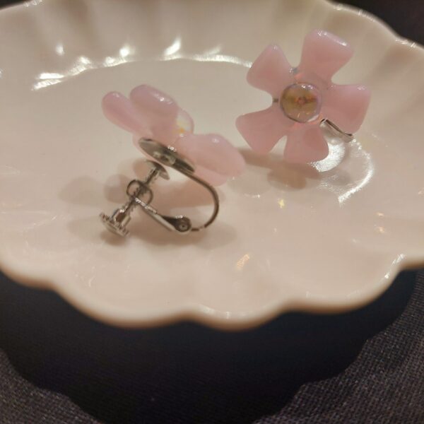 桜をイメージした、ガラスのピアスとイヤリングです。花びらにはふんわり優しい色合いをしたピンクのガラスを使用。 中心には玉虫色に輝くダイクロガラスを使用し、朝露がきらきら光る桜をイメージしました