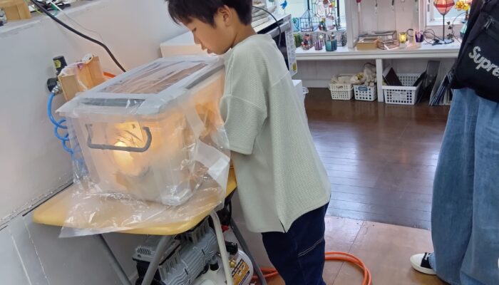 小学2年生の男の子がブラスト機を使い削っています。