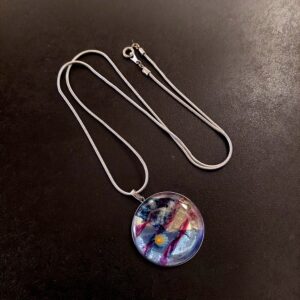 ガラスのペンダントネックレスです。クリアやブルー系のガラスが重なりあい、涼しげな水のせせらぎを思わせます。