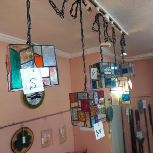 沢山のステンドグラスのキューブ型ペンダントランプをダクトレールに吊り下げて展示しています。